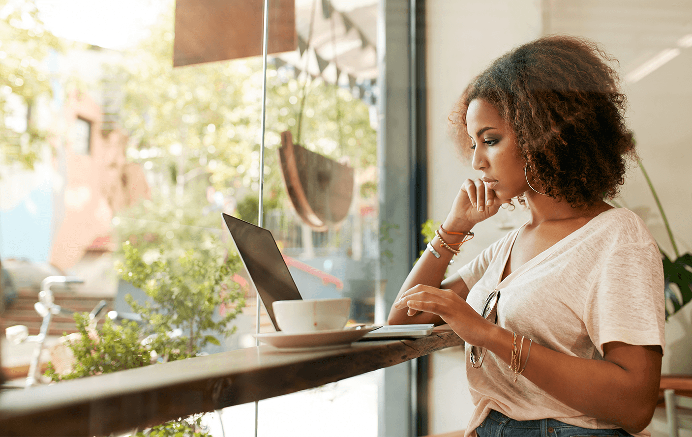 RDB: Mulher negra mexendo no notebook em um balcão.